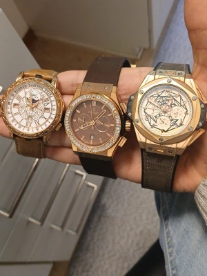 Tre exklusiva armbandsur i guldton - Säljer tre stilrena armbandsur i guldton med bruna och svarta läderband. Två av klockorna har gnistrande stenar runt urtavlan och en har romerska siffror. Alla har unika detaljer på urtavlan och ger en lyxig känsla till din outfit.