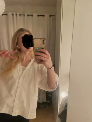 Vit skjorta med knappar - Säljer en vit oversized skjorta med klassisk krage och knäppning framtill. Skjortan har långa ärmar och är tillverkad i ett mjukt bomullstyg. Perfekt för en avslappnad och trendig look.