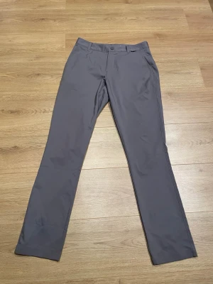 Grå golfbyxor från Puma - Snygga grå golfbyxor från Puma Golf med rak passform och klassisk design. Tillverkade i ett lätt och stretchigt material som passar perfekt för sportiga aktiviteter. Byxorna har knapp och dragkedja samt diskreta fickor fram.