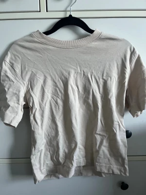 Beige basic t-shirt med rund hals - En enkel beige t-shirt med rund halsringning och korta ärmar. Perfekt för en clean och avslappnad stil. Passar till det mesta och är lätt att matcha med andra plagg. ❣️