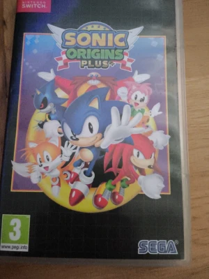 Sonic Origins Plus till Switch - Sonic Origins Plus till Nintendo Switch är ett färgglatt spel med klassiska Sonic-karaktärer som Sonic, Tails och Knuckles på omslaget. Spelet har en tecknad design och kommer i ett plastfodral. Perfekt för dig som gillar retroplattformsspel.