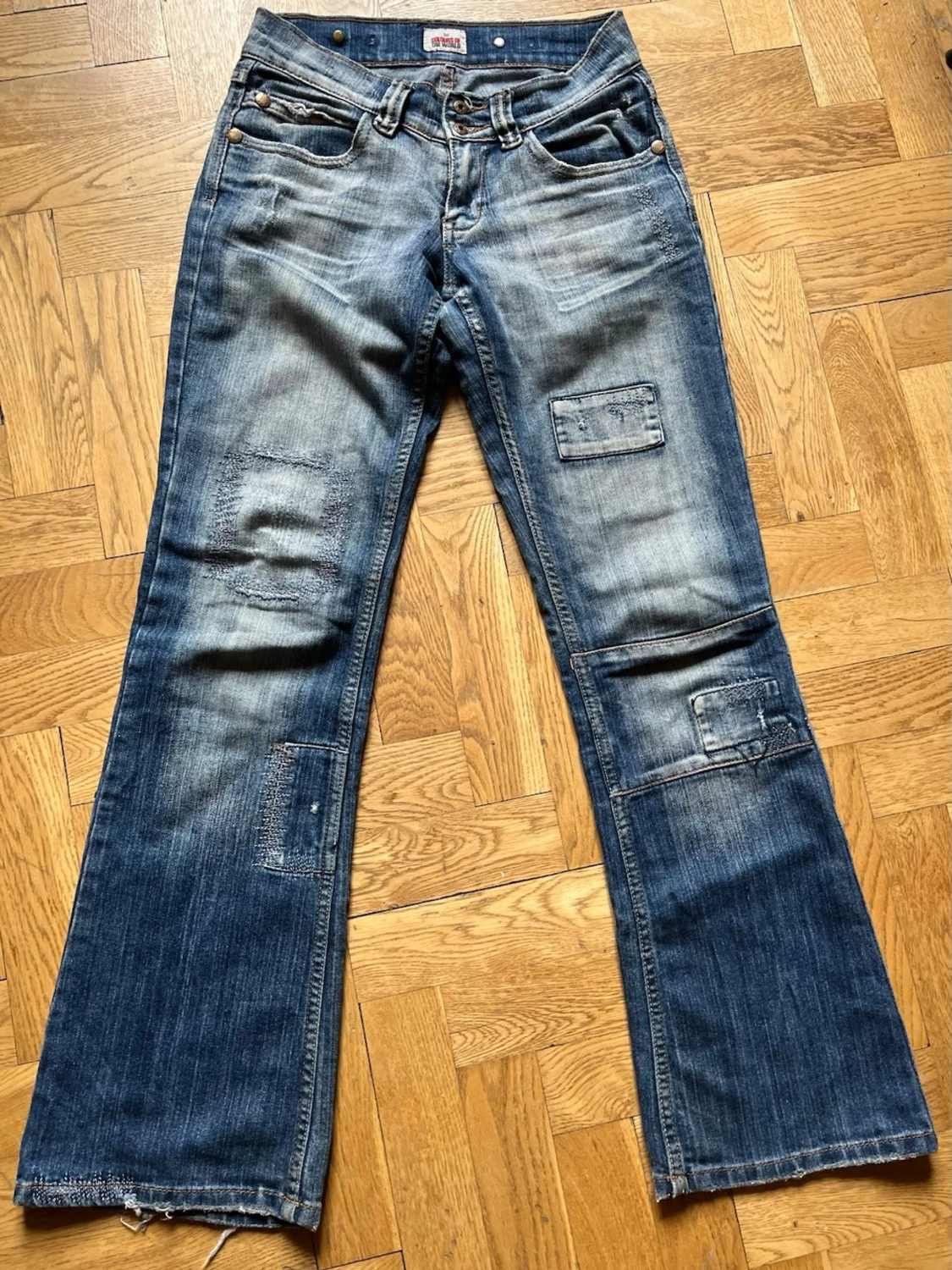 Blå bootcut jeans med patchdetaljer