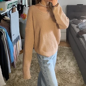 Stickad tröja - Supermysig stickad beige/rosa tröja från boohoo med en korsad öppen rygg💕 Bra på svalare sommarkvällar när det  inte är allt för kallt ute🌸 Tröjan är lite nopprig och har en har en slitning på ena ärmen (sista bilden)