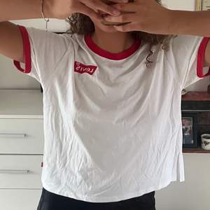 En vit fin T-shirt med röda detaljer! Sorlek xs men är ganska loose i fitten, sitter som på bilden på mig som i vanliga fall är en storlek s/m 🌼 är i väldigt bra skick! 🫶🏼