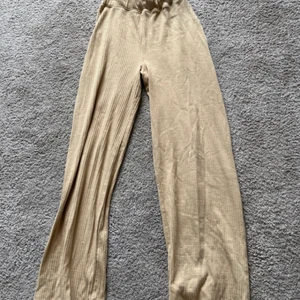 Ribbade byxor - Supersköna ribbade byxor med utsvängda ben. De kommer ej till användning längre så bättre att någon annan använder dom! Beige supermjukt material! Resår i midjan och sen svänger dom ut 