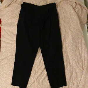 Svarta kostymbyxor med tillhörande bälte - Superfin kostymbyxa från H&M med ett tillhörande bälte för att kunna justera midjan. Används inte längre då de blivit alltför stora för mig. Är i bra skick och använts inte mer än 3 gånger. Originalpris: 400 kr