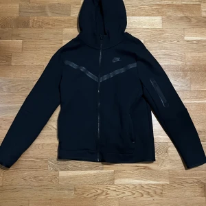 Svart Nike Tech  - - Helt oanvänd, nyskick. - Säljer pga fel storlek. - Köpt från JD, nypris: 950kr