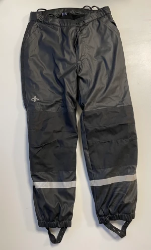 Mycket fina överdragsbyxor - Svarta vattentäta och fodrade överdragsbyxor från Cross Sportsware. Mycket bra skick.  Extra förstärkta på knä och på baken.   