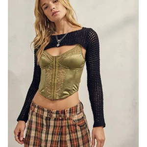 Svart stickad bolero Urban Outfitters - Säljer en oanvänd stickat bolero topp från Urban Outfitters. Den kan användas över korsett toppar, tröjor och på många flera sätt. Väldigt Bella Hadid.  Det är toppen på modellen och en bild på den jag har hemma. 