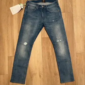 Ett par helt oanvända jeans som glömdes bort och jag nu säljer då de är för små. De är lite uppsydda i butik och har ny storlek 30/29. Modellen heter Luke och har fabriksgjorda slitningar på knäna.