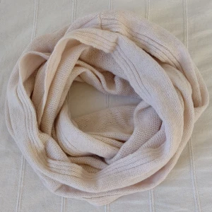 Oanvänd ljusrosa/beige stickad halsduk/tubhalsduk - Oanvänd stickad tubhalsduk i en jättefin ljus beigerosa och melerad färg. Ca 150 cm lång och 58 cm bred. Relativt tunn. 50% akryl 35% polyamid och 15% ull. På den första bilden är halsduken snurrad två gånger. 