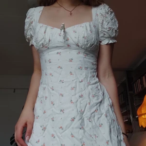 Småblommig Klänning - Så fin klänning köpt på Urban Outfitters för 600 kr! Små rosa blommor, puffärmar och fina detaljer. Superfin passform med smal midja. Två lager tyg, så inte alls genomskinlig. Sparsamt använd, men lite gulaktig vid högra bröstet (knappt synligt). 