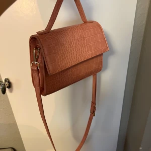 Väska  - Jättefin rymlig rosa väska med kort och långt band, från åhlens och är aldrig använd. Inköpt för ca 350:-. Vid köp står kund för eventuell frakt. 💕 