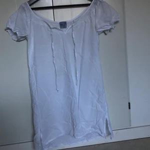 Vit klänning - Vit klänning i storlek M. Med snören man knyter där fram. Köpt secondhand. Märket är Line of Oslo. 