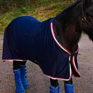 JH collection fleecetäcke💙 - Marinblått fleecetäcke med röda och vida detaljer från JH collection. Svansrem och magkryss jordar. Nyskick, endast använt 2 gånger💙 köparen står för frakten🦋