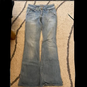 Lågmidjade hudson jeans - Ett par supersnygga ljusa, lågmidjade och utsvängda jeans från märket Hudson. Har ett litet hål på vänstra knät (se bild 3) Köpare står för frakt:)
