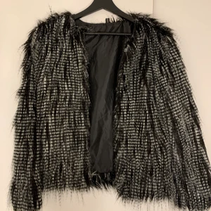 Fuskpäls jacka - Jättesnygg jacka i fuskpäls i väldigt fint skick, använd några gånger men ser fortfarande helt ny ut. Inga skadade ställen. Storlek L men passar mer M då jag inte kunnat stänga den på mig själv som är en L vanligtvis i kläder. Stängning är i silverfärgade hakar så sitter på bra. Minns ej pris eller ställe köpt från. 