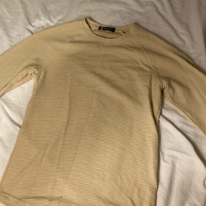 Beige tajt långärmad tröja - Väldigt fin tröja för finare möten. Sitter tajt och ser bra ut med upp dragna ärmar. 