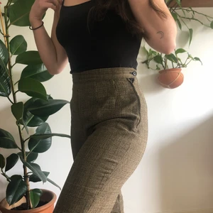 Kostymbyxor - Bruna rutiga kostymbyxor. Köpta på second- handaffär i Malmö.  Midjemått 68cm. Innerbenslängd 70cm.