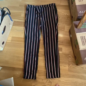 Mango Randiga kostymbyxor - Dessa kostymbyxor är stretchiga med svart vit röda ränder. Favorit men säljs pga att de blivit för små och flytt! 