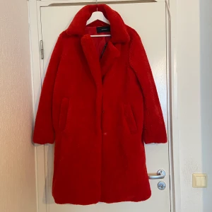 Vero Moda - Röd falsk päls jack från vero moda i storlek L, lite större så kan funka för L/XL. Aldrig använt, prislapp på, kostade 800kr. Kan mötas upp (Västerås) eller skickas via postnord, köpare betalar frakt.
