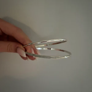 Två armband i rostfritt stål - Två silverarmband i rostfritt stål, ej äkta silver. Aldrig använda och passar dig som har en liten större handled. 30 kr st. 50 kr för båda.