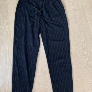 Blåa byxor Mango - Blåa tygbyxor från Mango storlek S