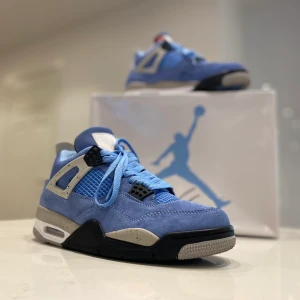 Jordan 4 ( UNC )  - Jag säljer ett par Jordan 4 UNC i storleken 40. Det är unisex skor så det passar både män och kvinnor. Skorna är använda en gång och är fortfarande i nyskick. På bilderna så ser färgen mörkare ut än vad dom egentligen är. 