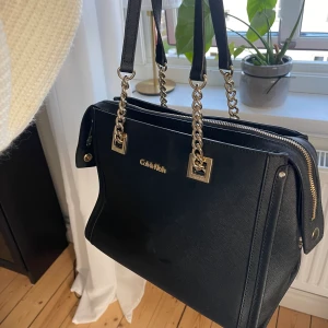 Calvin Klein väska - Svart äkta CKväska med guldiga detaljer. Perfekt vardagsväska. Köparen står för eventuell frakt