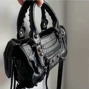 Balenciaga väska - Säljer nu min SKITSNYGGA balenciaga liknande väska!! Bra skick förutom att banden på ena sidan har lossnat, man kan även välja att ta av de om man vill det annars ser den EXAKT ut som på den första bilden. Köpt för 800 säljer för endast 400!❤️kontakta för fler bilder!💘