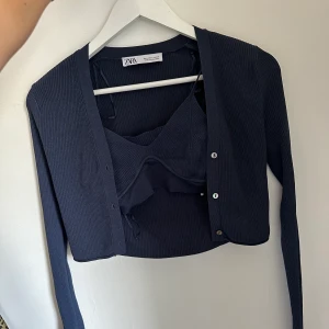 Ribbat set från Zara - Jättefint marinblått ribbad set från Zara med en bh/topp och en fin långärmad kofta till. Båda delarna är i strl M. Aldrig användt då det tyvärr var en förliten present som jag nu hoppas får användning hos nån annan:)