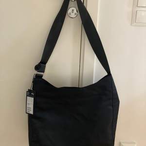 Helt ny/oanvänd svart väska från Weekday i modellen ”Carry”. 38 x 33 x 14 cm. Nypris 390 kr. 