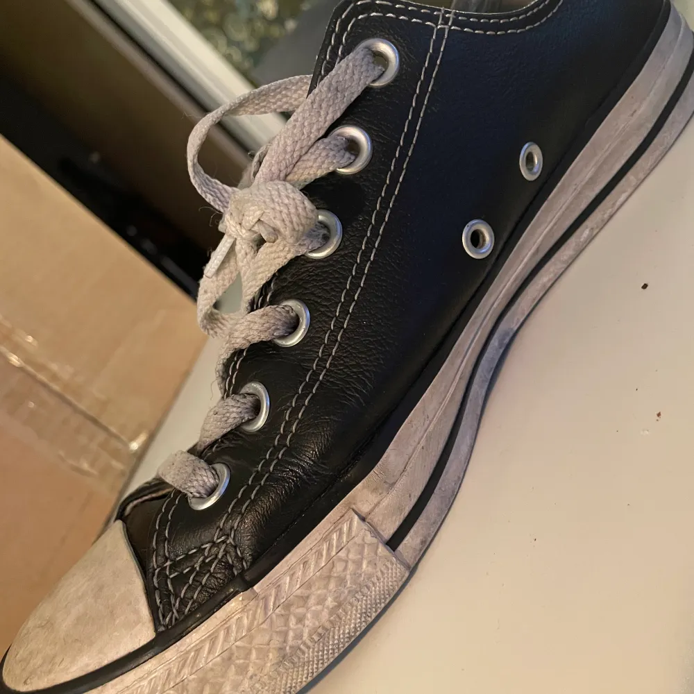 Låga Converse i svart läder. 6.5 men och 8.5 women i amerikans storlek. De har tyvärr traskat i blåbärsris, och ser därför ut som de gör. . Skor.