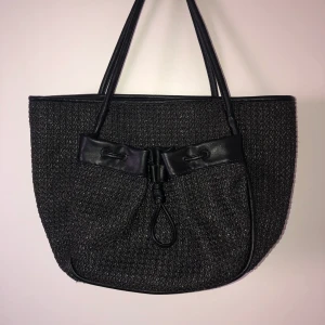 väska från Ulrika Design - svart väska från Ulrika Design! använd en gång. fick den av min mamma då hon beställt fel och inte gick att returnera. insåg dock ganska snabbt att den inte alls är min stil så den har bara blivit liggande! materialet är syntet/fake-skinn. nypris ca 599kr