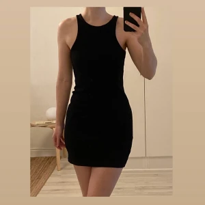 Ribbad svart klänning strl M - Snygg och skön ribbad svart klänning i strl M (känns mer som en S men väldigt stretchigt material). Endast använd ett fåtal gånger. 