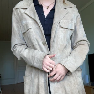 Beige mockakappa - En beige mockakappa i storlek 42 men passar mig som är storlek 36 och är 175cm lång. 100% äkta mocka. 