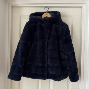 Samsøe Samsøe pälsjacka - Jättefin faux-pälsjacka med stor luva. Varm och mycket mysig att ha på sig. Har används men är i bra skick. Lite slitage på insida men inget att påpeka på det yttre. 