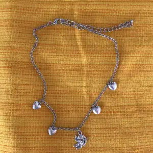 Silverfärgat halsband med hjärtan och ängel. Icke äkta silver. Aldrig använt och tror att det är köpt på shein eller likande för några år sedan. Strl: 41-52cm 15kr+frakt