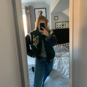  Grön Collegejacka - Säljer denna gröna college jacka från H&M då den ej kommer till användning längre. Den är oversiszed och köptes för ca 499kr. Använd en gång. Köpare står för frakt.