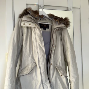 Woolrich jacka - Säljer denna super snygga jackan från woolrich. Den är varsamt använd och finns inga tecken på användning. Den har en du dubbeldragkedja för att behålla värmen extra bra. Huvan har en pälskrage med päls även inuti huvan. Nypris av denna jackan var 9000kr