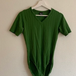 Secondhand topp  - En snygg secondhand topp som ge att knäppa längst ner. Stretch i material. 