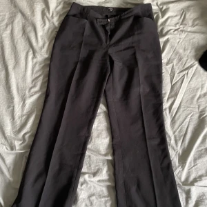 Kostymbyxor  - Lågmidjade svarta byxor med vida ben