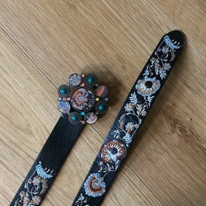 Blommigt skärp - Unikt skärp från Desigual🎀 Man kan vända den så att det båda kan vara blommigt och svart! Måttet är 108cm långt och jag har gjort några hål själv så det passar väldigt många storlekar