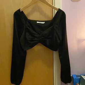 Croppad tröja - Svart croppad tröja från nakd i siden liknande tyg. Använd 1 gång. Köparen står för frakten 💕