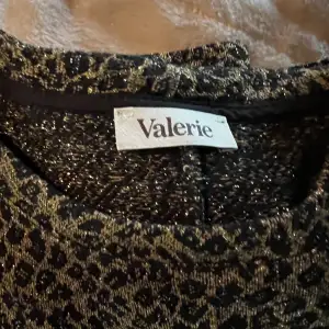 Valerie: Leopardmönstrad topp med glittersömmar och lite puffärm  49% bomull, 26% polyester, 21% viskos, 4% p  Använd ett fåtal gånger   Ej skråmor eller förändringar i material