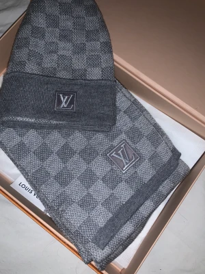 Louis Vuitton set - Louis Vuitton damier petit grå mössa och halsduk i bra skick. Säljes tillsammans så fråga inte om att köpa separat. Låda osv följer med.  Mössan retail: 3000kr  Halsduken retail: 5149kr ($475) INGA BYTEN
