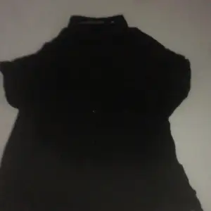 En svart skjorta med knappar och en ficka på bröstet. Har andvänt några gången men passar inte längre. Den ser ut som ny