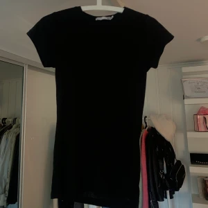 Ribbad t-shirt - Säljer denna perfekta basic svarta ribbade t-shirten ifrån lager 157 i storlek S. De är ett bas plagg som funkar till allt och den formar sig snyggt efter kroppen.  (På andra bilden ser ni de ribbade mer)