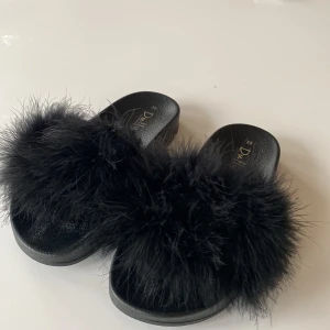 Tofflor med fluff - Tofflor med fluff på bandet över foten. 