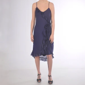 Lila kortklänning med volanger - Fin lila kortklänning med blomma och volanger  Modellen är 173 cm och bär klackskor.  (Fler bilder finns! - Skriv isf)